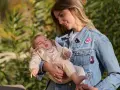 Mamma con bimbo in braccio, un'idea su come vestire i bambini in questo periodo con un morbido completo e giacca di jeans.