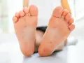 Piedi di bambino con eruzione cutanea, possibile contagio mani bocca. I genitori preoccupati cercano risposte.
