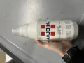Mano tiene flacone Amuchina per disinfettare ciuccio. Soluzione disinfettante concentrata per igiene.