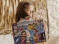 Bambina con scatola "Sirene Mega Box Arts & Crafts". A che età si impara a leggere? Forse con questo kit creativo, l'apprendimento sarà più divertente!