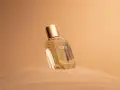 Flacone di profumo "Eden" su sabbia dorata. Un body mist cos'è? Una fragranza leggera per rinfrescarsi.