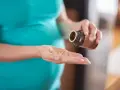 Donna incinta prende capsule, preoccupata per possibili augmentin effetti collaterali.