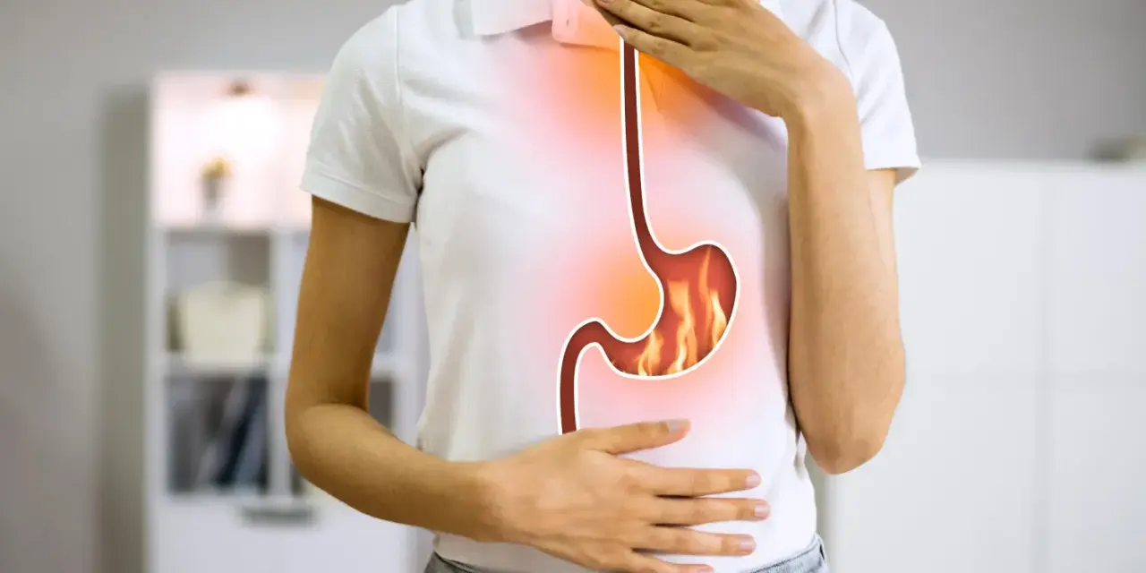 Persona con bruciore di stomaco, immagine di un esofago e stomaco infuocati. Potrebbe essere utile omeprazen 20 mg.