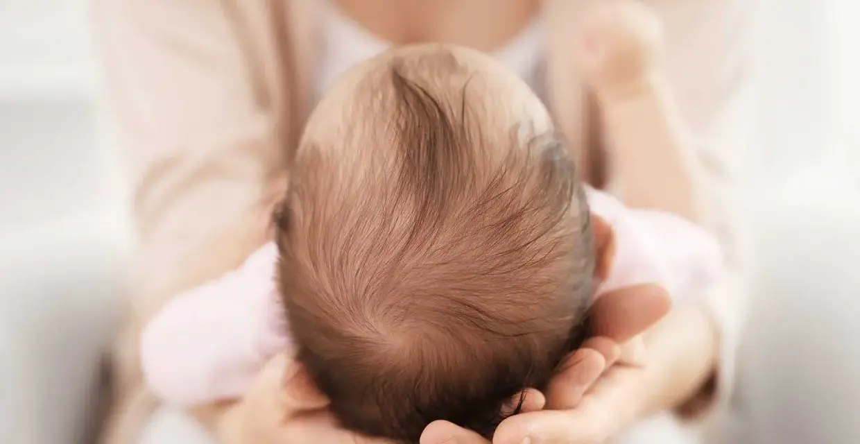 Dolcezza infinita nel tenero abbraccio, mentre la fontanella del neonato si prepara a chiudersi.