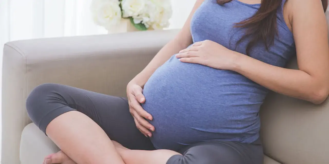 Donna incinta accarezza il pancione, pensando alla possibile perdita del tappo mucoso durante la gravidanza.