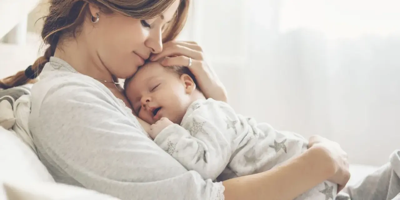 Dolce momento di una madre che culla il suo neonato. La gravidanza a 43 anni è un dono prezioso.
