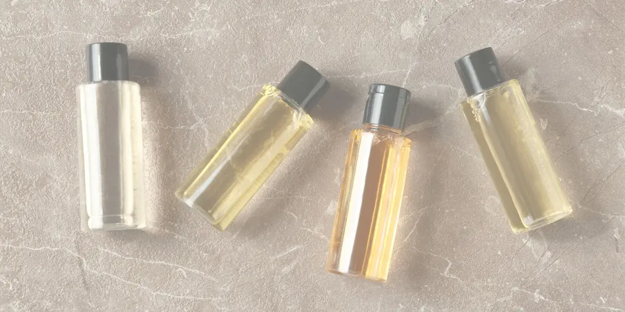 Quattro boccette di profumo su sfondo marmorizzato. Anche i profumi scadono, ma questi sembrano ancora pronti per essere usati.