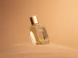 Flacone di profumo "Eden" su sabbia dorata. Un body mist cos'è? Una fragranza leggera per rinfrescarsi.