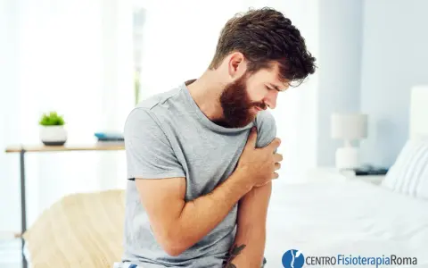 Uomo con barba che si tiene il braccio sinistro, avvertendo un fastidioso formicolio.