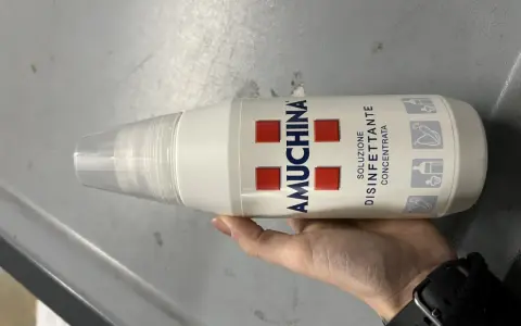 Mano tiene flacone Amuchina per disinfettare ciuccio. Soluzione disinfettante concentrata per igiene.