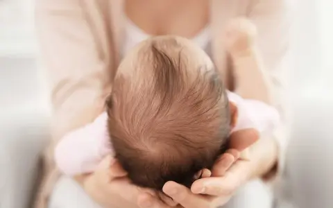 Dolcezza infinita nel tenero abbraccio, mentre la fontanella del neonato si prepara a chiudersi.