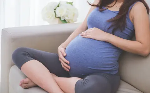 Donna incinta accarezza il pancione, pensando alla possibile perdita del tappo mucoso durante la gravidanza.