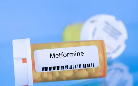 Flacone di Metformina 500 mg, con pillole gialle visibili.