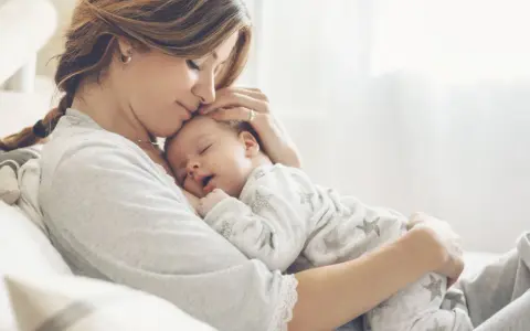 Dolce momento di una madre che culla il suo neonato. La gravidanza a 43 anni è un dono prezioso.