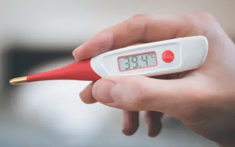 Termometro digitale mostra 39.4°C. Febbre alta, serve antibiotico e tachipirina.