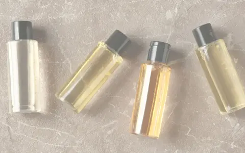 Quattro boccette di profumo su sfondo marmorizzato. Anche i profumi scadono, ma questi sembrano ancora pronti per essere usati.