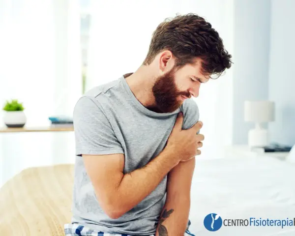 Uomo con barba che si tiene il braccio sinistro, avvertendo un fastidioso formicolio.