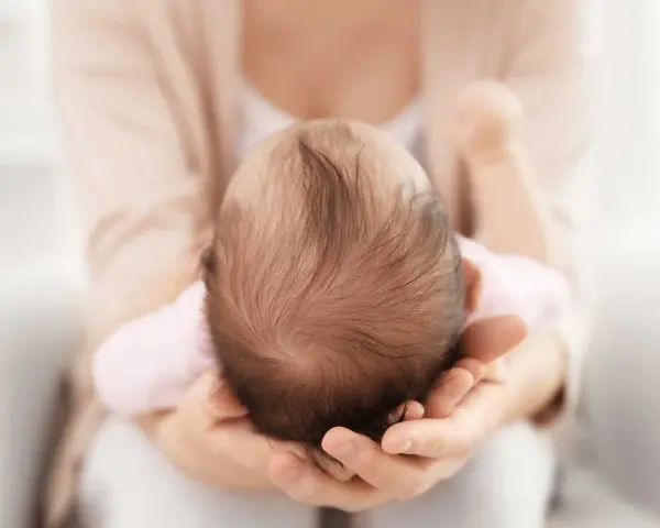 Dolcezza infinita nel tenero abbraccio, mentre la fontanella del neonato si prepara a chiudersi.
