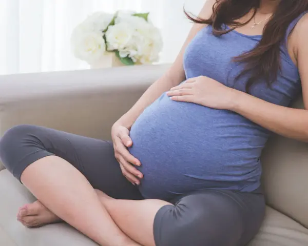 Donna incinta accarezza il pancione, pensando alla possibile perdita del tappo mucoso durante la gravidanza.