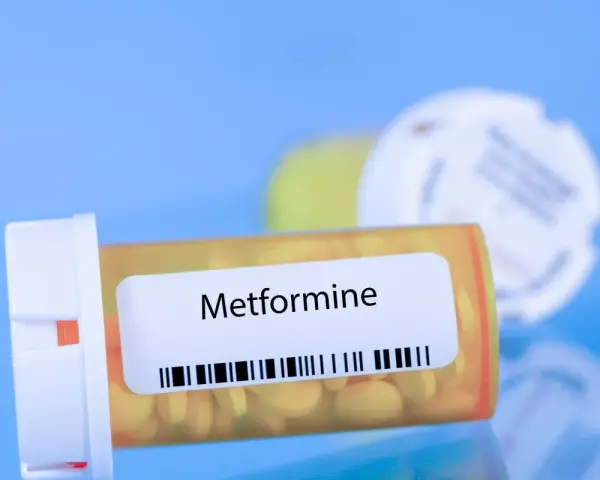 Flacone di Metformina 500 mg, con pillole gialle visibili.