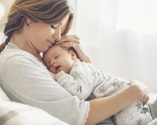Dolce momento di una madre che culla il suo neonato. La gravidanza a 43 anni è un dono prezioso.