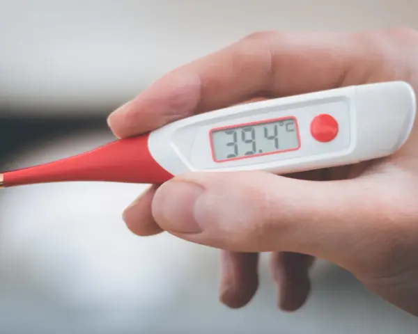 Termometro digitale mostra 39.4°C. Febbre alta, serve antibiotico e tachipirina.