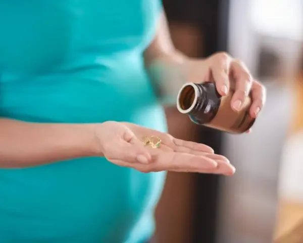 Donna incinta prende capsule, preoccupata per possibili augmentin effetti collaterali.
