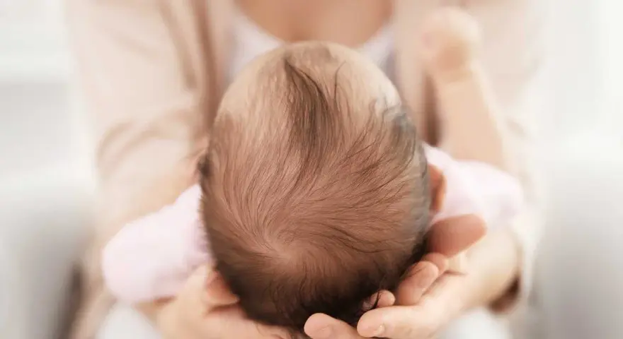 Dolcezza infinita nel tenero abbraccio, mentre la fontanella del neonato si prepara a chiudersi.