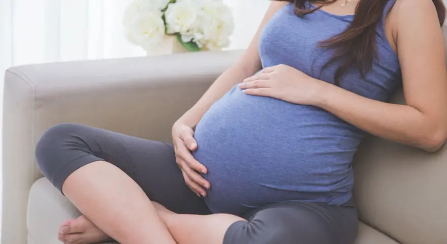 Donna incinta accarezza il pancione, pensando alla possibile perdita del tappo mucoso durante la gravidanza.