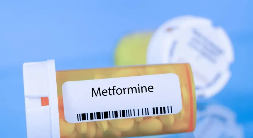 Flacone di Metformina 500 mg, con pillole gialle visibili.
