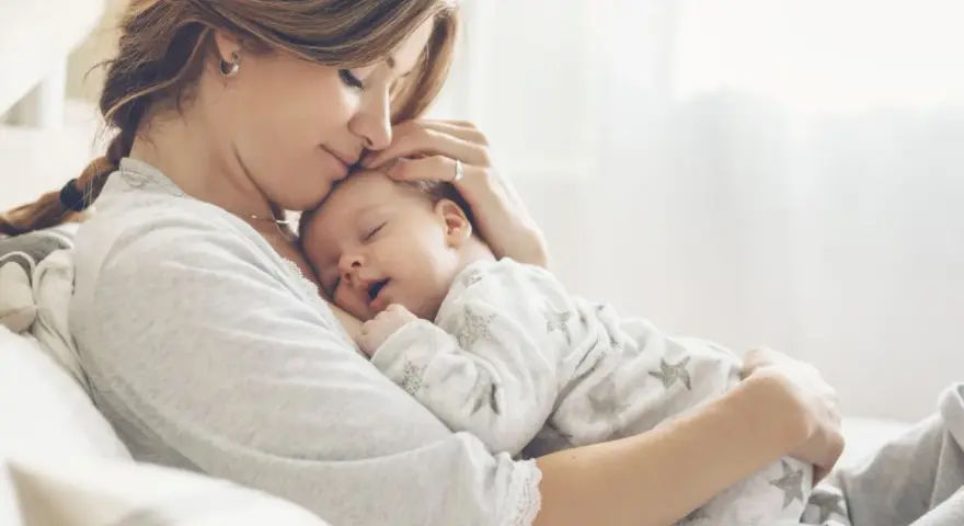 Dolce momento di una madre che culla il suo neonato. La gravidanza a 43 anni è un dono prezioso.