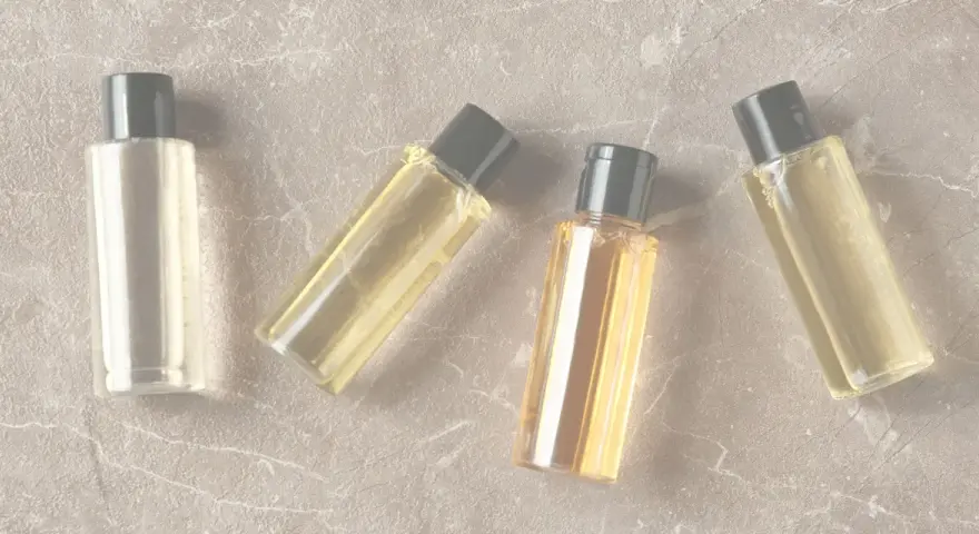 Quattro boccette di profumo su sfondo marmorizzato. Anche i profumi scadono, ma questi sembrano ancora pronti per essere usati.