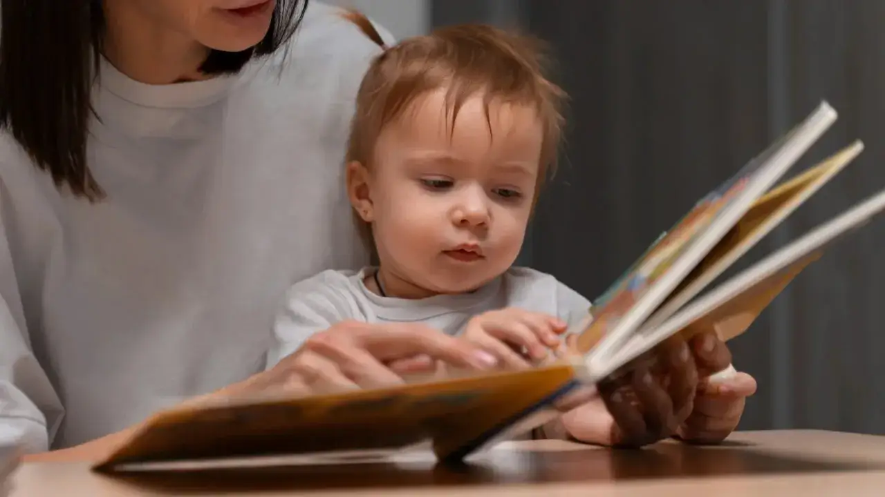 Bambina con mamma sfoglia un libro, forse è il momento in cui inizia la lallazione.