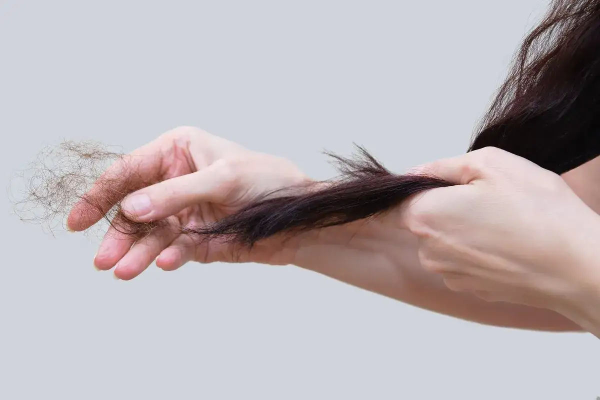 Mani che mostrano perdita capelli allattamento. Si cercano rimedi per capelli più forti e sani.