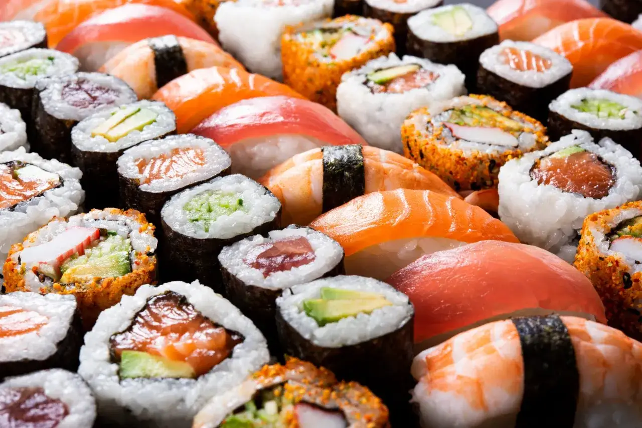 Un assortimento di sushi, tra cui nigiri con salmone e tonno, e maki con avocado e cetriolo, pronto per essere gustato.
