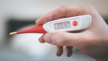 Termometro digitale mostra 39.4°C. Febbre alta, serve antibiotico e tachipirina.